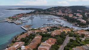 A coastal town with a marina, terraced houses, and a clear view of the sea.