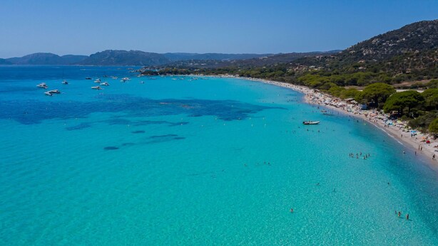 A coastal beach with clear turquoise waters, boats, and a sandy shore with trees. - La Cupulatta by Interhome (Sainte Lucie Porto Vecchio)
