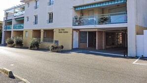 A multi-story building with balconies, a covered entrance, and a sign reading "Le Clés Saint-Saëns". - Le Clos Saint Saens by Interhome (Saint Aygulf)