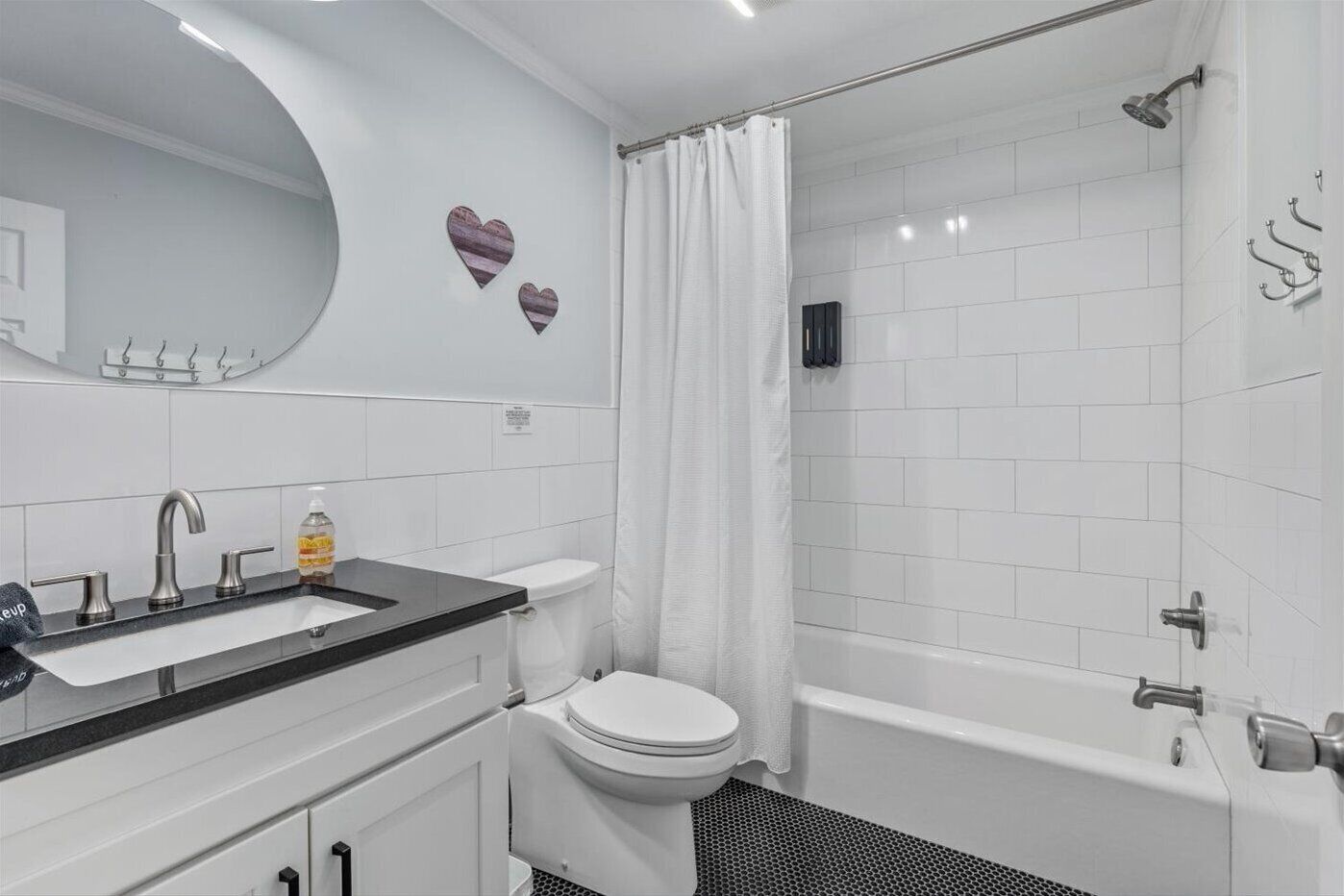 A modern bathroom with a white sink, toilet, and bathtub.
