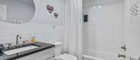 A modern bathroom with a white sink, toilet, and bathtub.