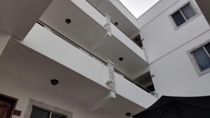 A multi-level building with balconies and a skylight. - Hotel Yukon (Playa del Carmen)