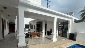 A covered outdoor area with a pool, a foosball table, and a grill. - Hotel Yukon (Playa del Carmen)
