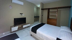 A hotel room with two beds, a TV, a wardrobe, and a bathroom visible in the background. - Hotel Yukon (Playa del Carmen)