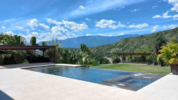 Une piscine offrant une vue sur les montagnes et un ciel dégagé.