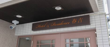 L’entrée d’un hôtel, avec une enseigne indiquant « Hôtel Résidence ».