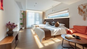 Une chambre d’hôtel moderne, dotée d’un grand lit, d’un canapé, d’une table basse et offrant une vue sur l’extérieur.