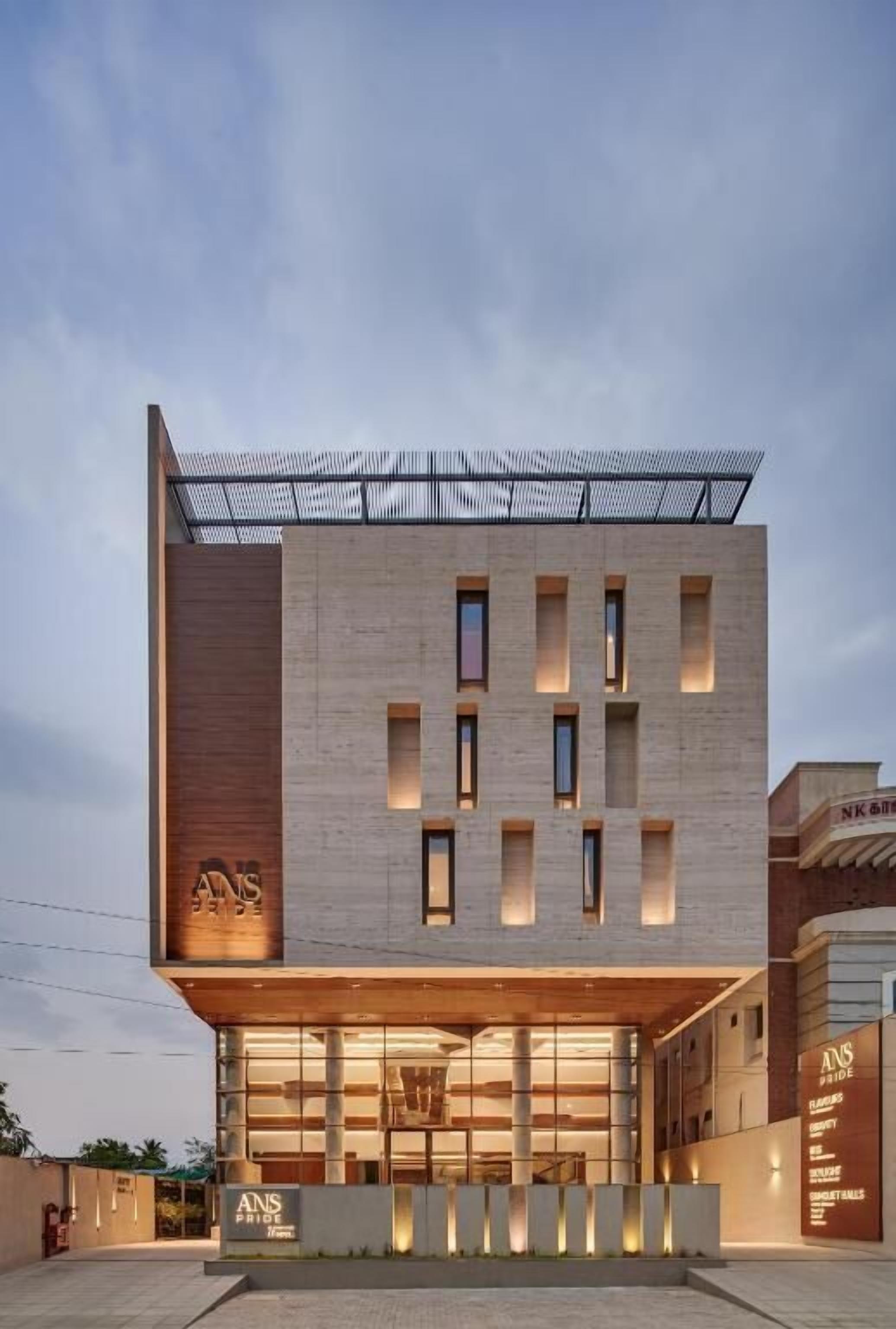 Un edificio moderno con tejado plano, ventanas amplias y una entrada destacada.