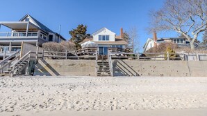 A beachfront property with a main house, a secondary building, and a staircase leading to the beach.