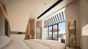 Une chambre moderne avec un grand lit, une fenêtre de toit et une vue sur l’extérieur.