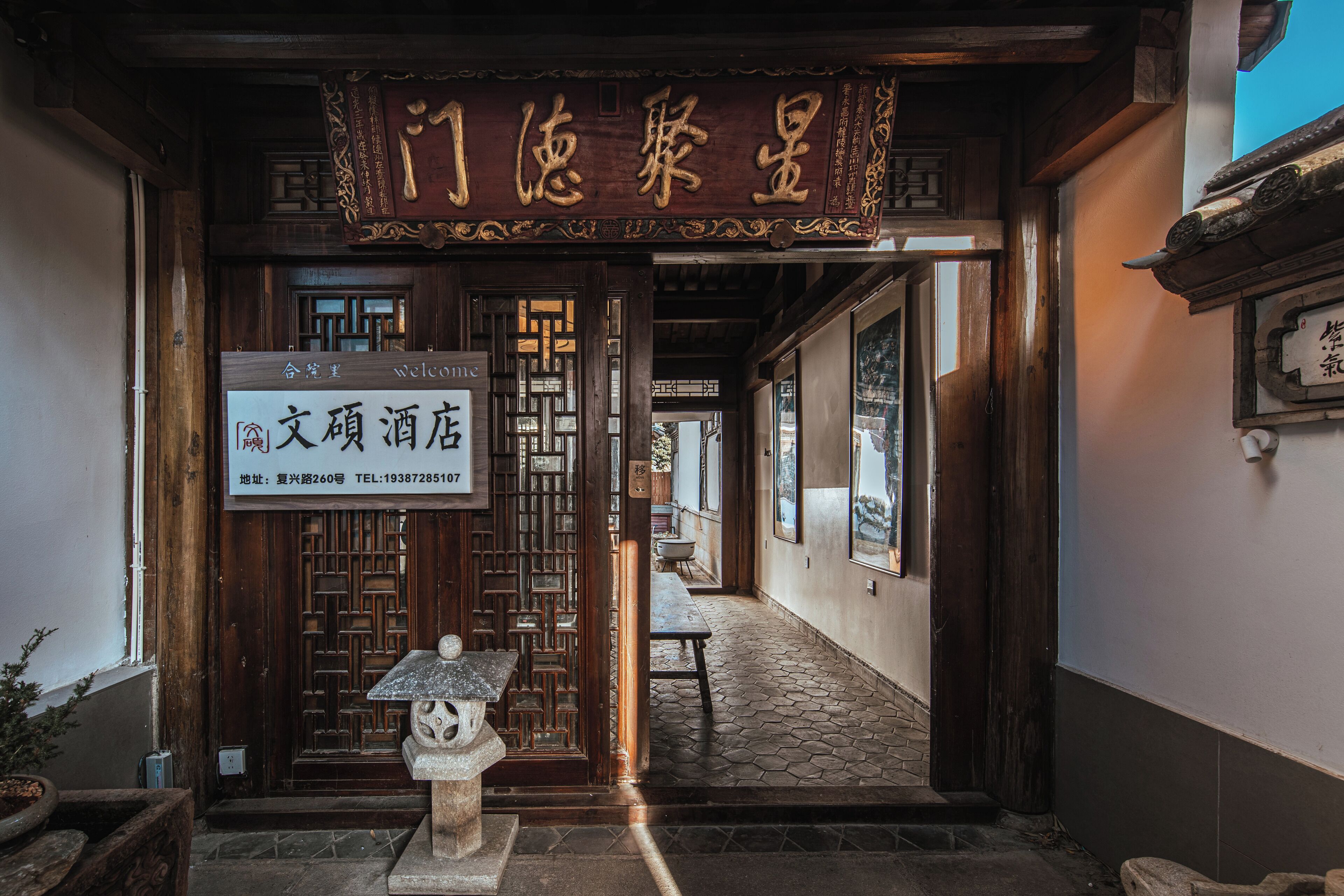 A traditional Chinese entrance with a wooden door and a stone lantern.
