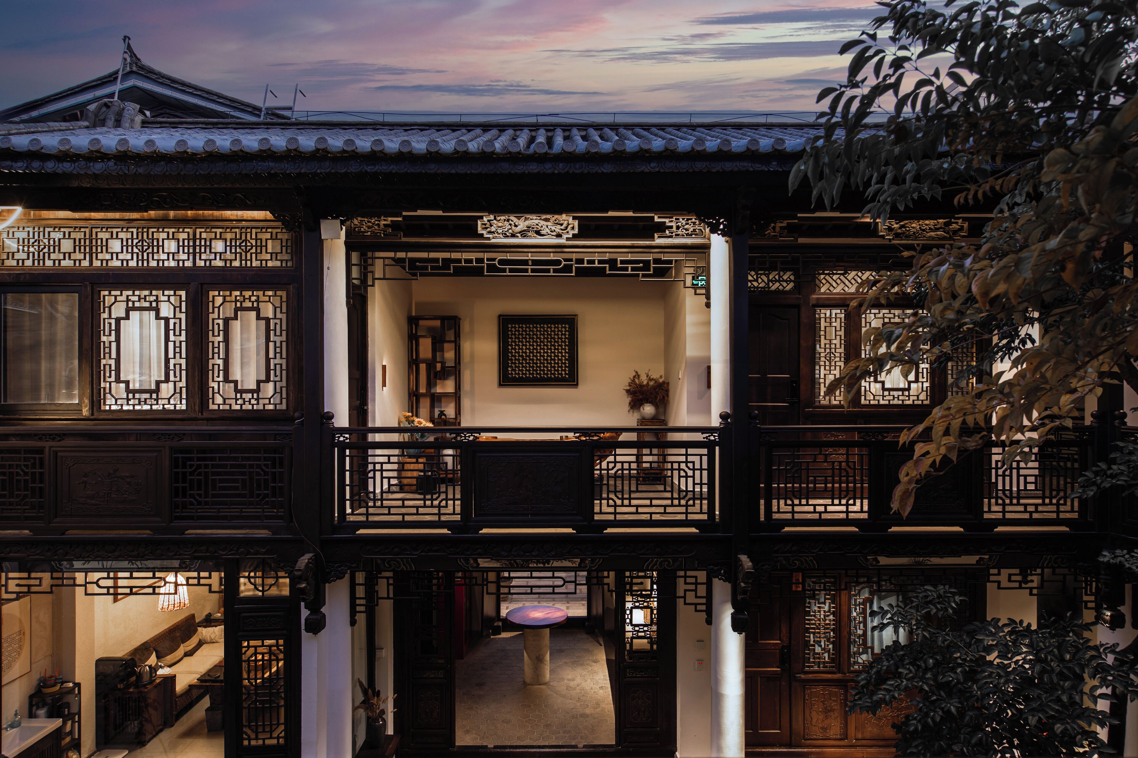 Ein traditionelles chinesisches Gebäude mit mehreren Balkonen, einem Innenhof und aufwendigen Holzgitterarbeiten.