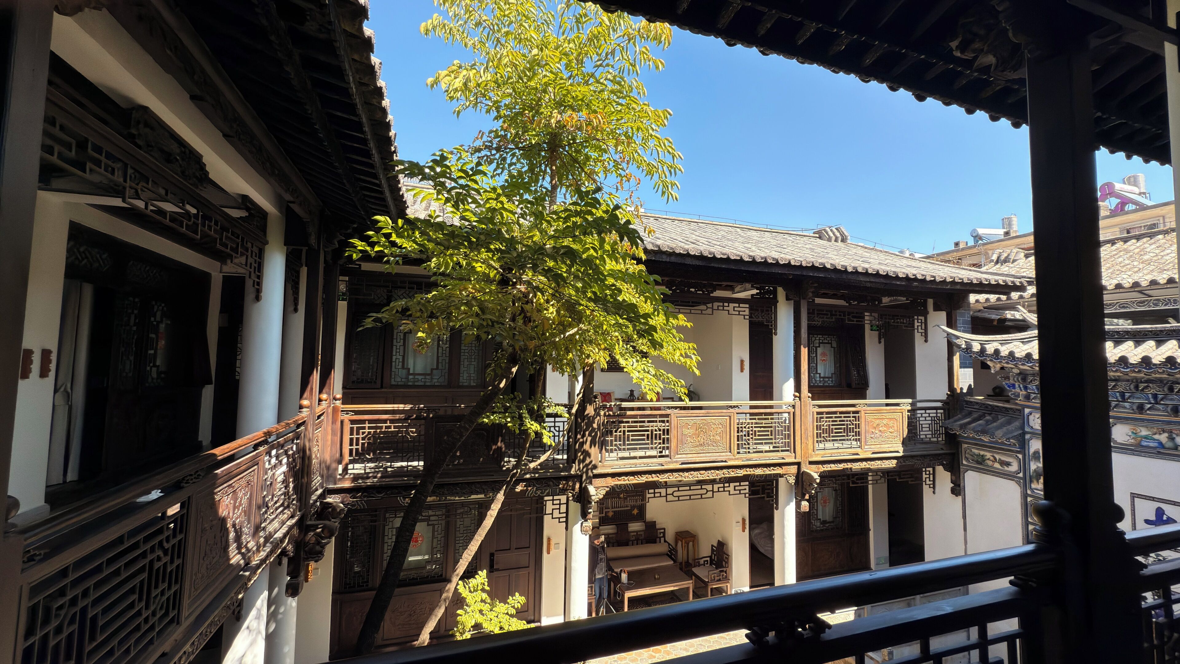 A traditional building with a balcony and a tree in front.