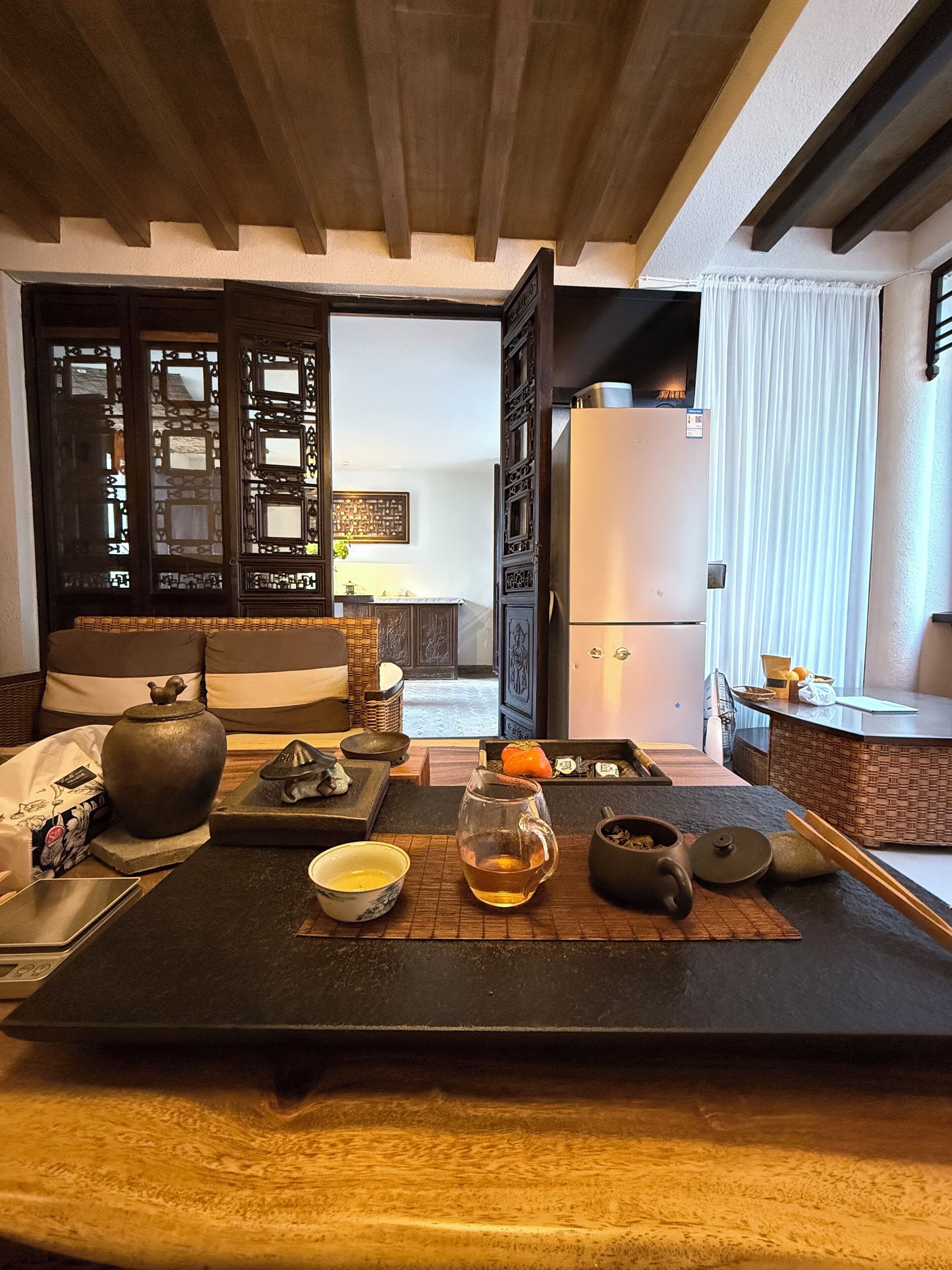 A traditional Japanese-style kitchen with a tatami mat table, a refrigerator, and various kitchen utensils.