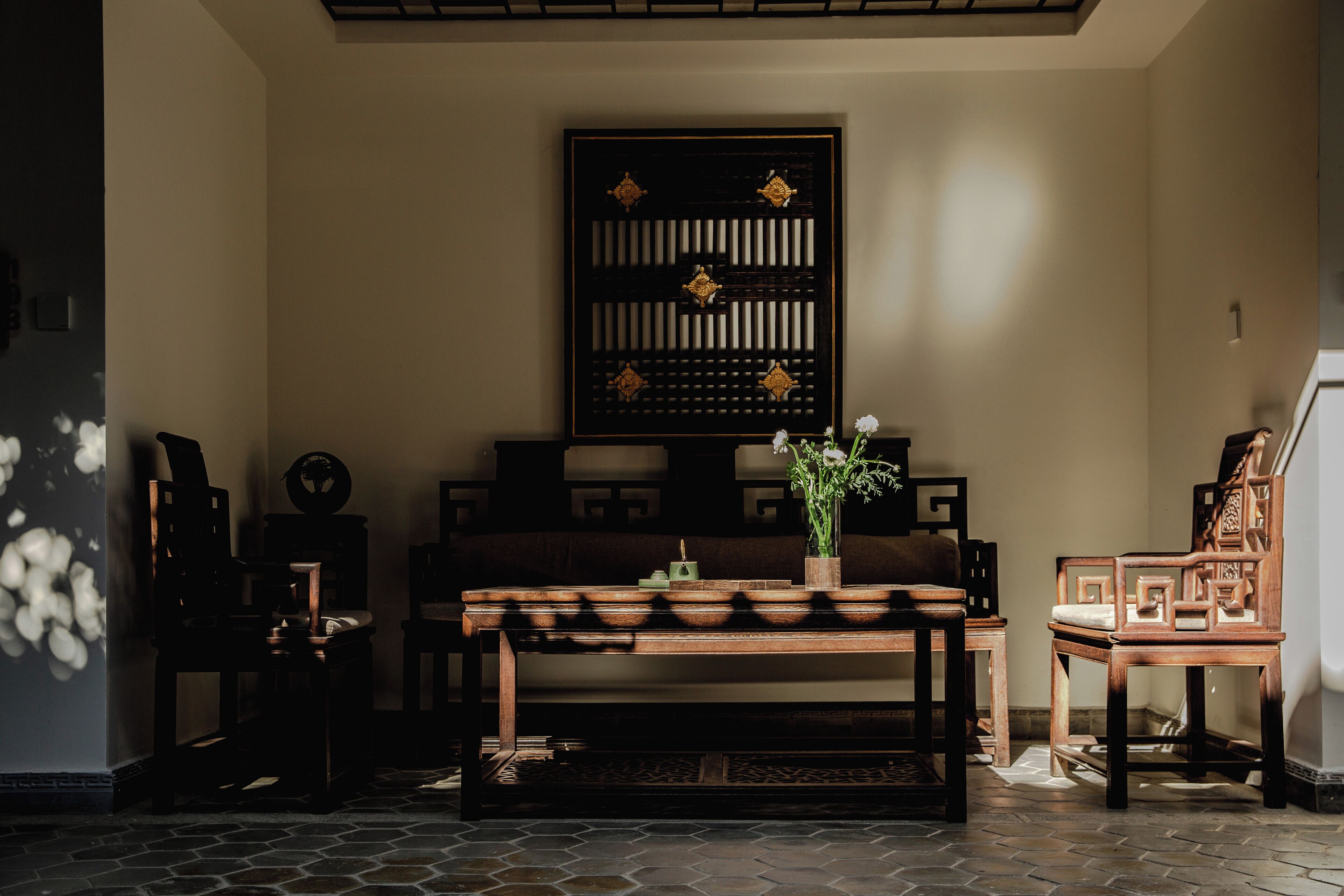 A traditional room with a wooden table, chairs, and a decorative screen.