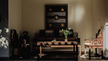 Una habitación tradicional con una mesa de madera, sillas y un separador decorativo.