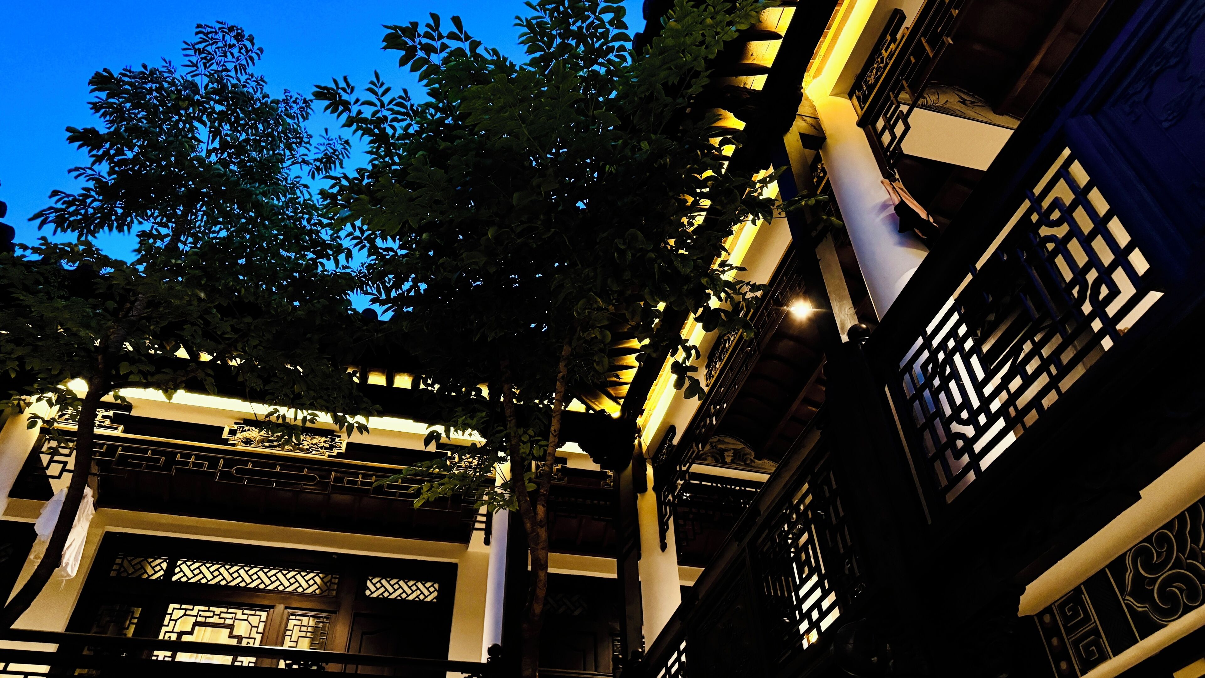 A traditional building with intricate wooden lattice windows and a balcony with a railing.