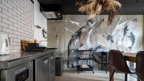 Eine moderne Küche mit Geschirrspüler, Kaffeemaschine und Essbereich mit Tisch und Stühlen.
