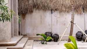 A courtyard with a thatched roof, concrete steps, and potted plants. - Villa Nubia at Bocoa Villas (Canggu)