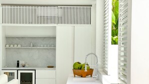 A modern kitchen with white cabinetry, a marble countertop, and a built-in wine cooler. - Villa Atara - 2BR Premium Private Pool Villa Pererenan (Kecamatan Mengwi)