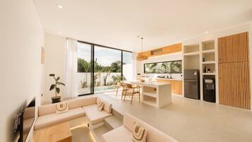 Eine moderne Küche mit Essbereich, einem integrierten Kühlschrank und einem großen Fenster mit Blick auf einen Pool.