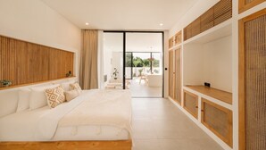 Un dormitorio moderno con una cama grande, cabecera de madera, televisor y puerta corredera de cristal que da a un espacio exterior.