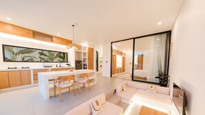 A modern interior with a dining area, kitchen, and a living space with a large window. - Alcove Boutique Private Pool Villa D (Kecamatan Kuta Selatan)