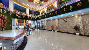 A spacious lobby with a marble floor, a stage, and a decorative ceiling. - Narayan Marriage Hall And resort  (Sitamarhi)