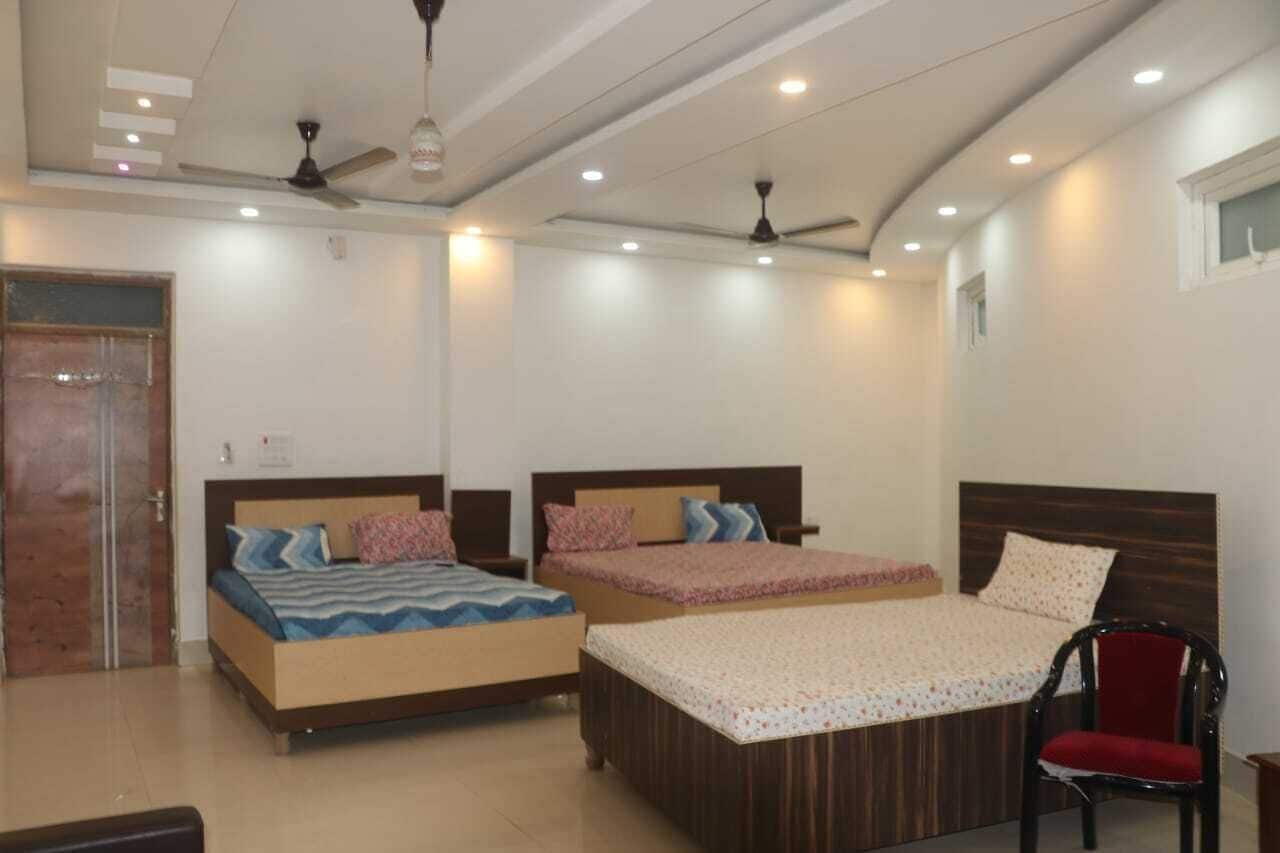A bedroom with two beds, a ceiling fan, recessed lighting, and a window.