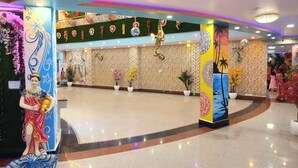 A lobby with a central reception area, decorative pillars, and a floral arrangement. - Narayan Marriage Hall And resort  (Sitamarhi)