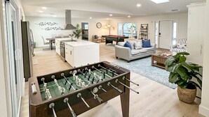 A spacious living area with a foosball table, a sofa, a coffee table, and a TV. - 5-bedroom home in Port Charlotte (Port Charlotte)