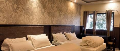 A hotel room with two beds, a ceiling fan, and a window with curtains.