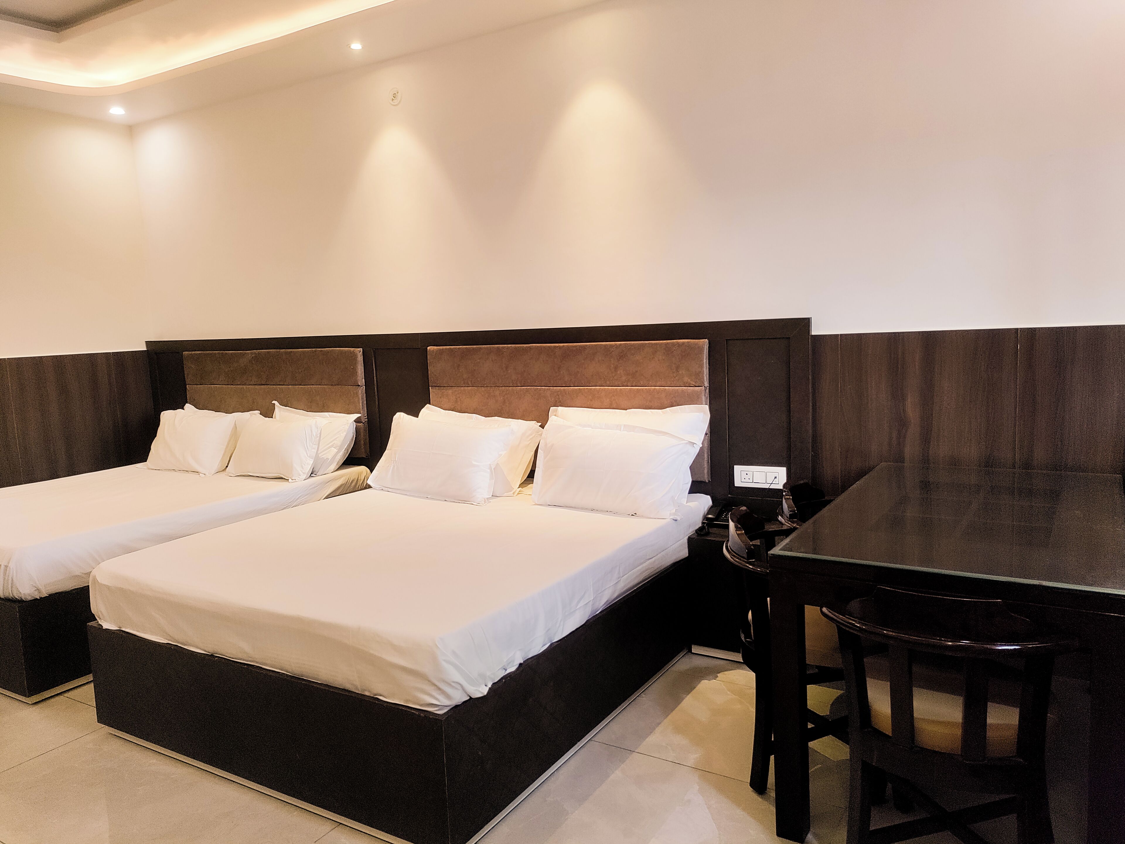 Una habitación de hotel con dos camas, un escritorio y una silla.