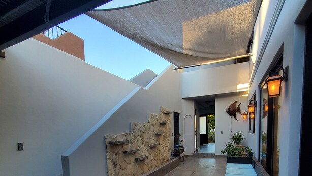 A modern outdoor area with a stone wall, a wooden bench, and a staircase. - Pristine 3-bed, 3.5-bath villa with mountain, golf course, sea views & hot tub 
 (Loreto)