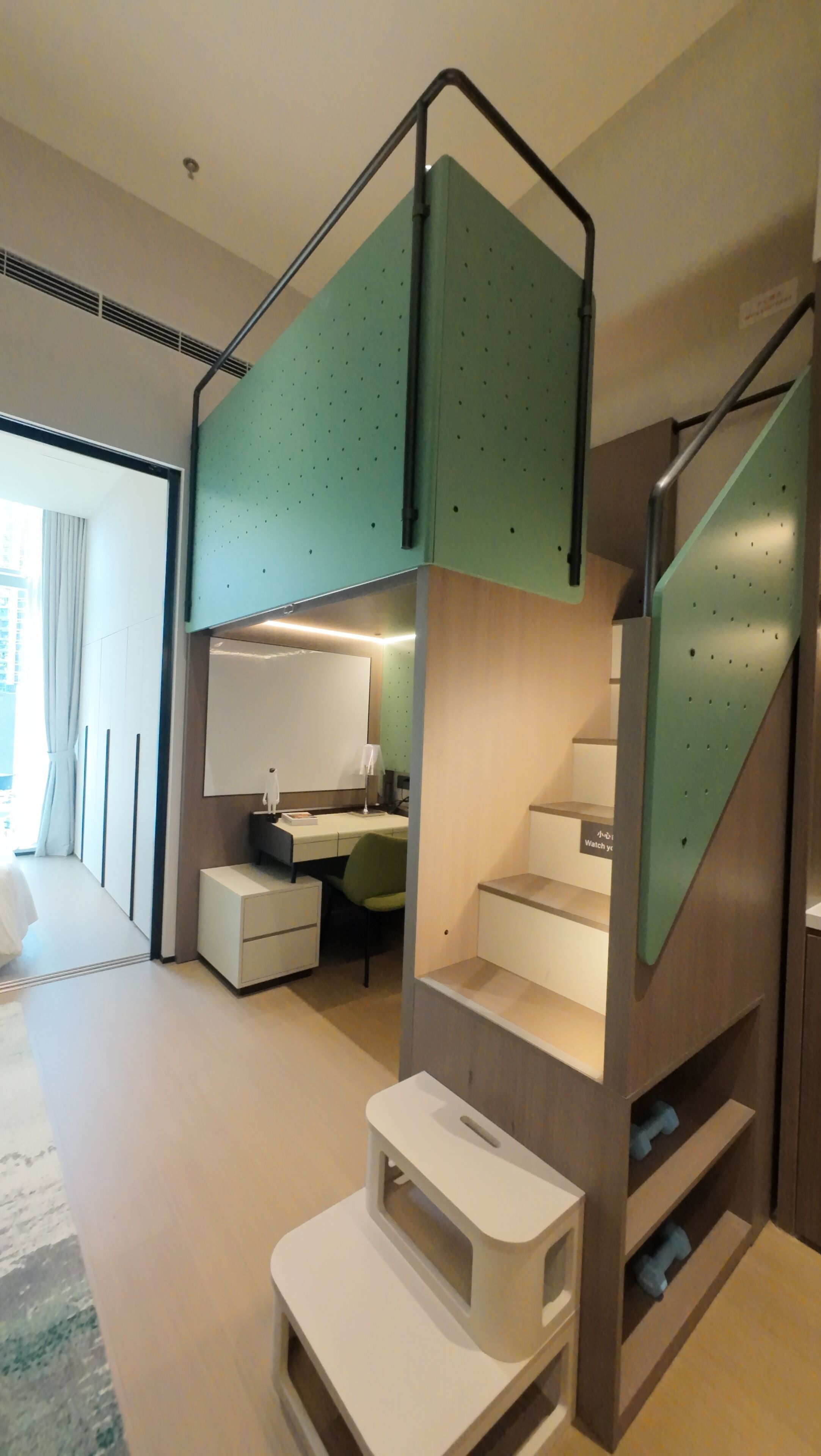 A modern interior with a staircase, a desk, and a bed.