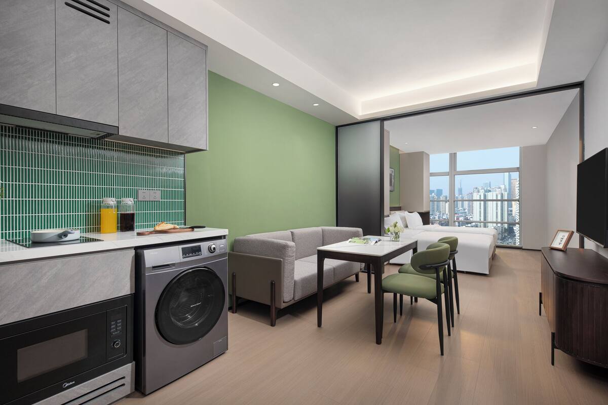 A modern apartment with a kitchen, a dining area, a living room, and a bedroom.