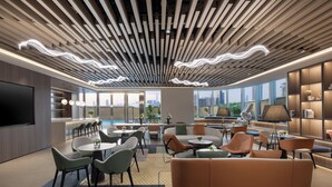 A modern lounge area with a large sofa, multiple seating options, a flat-screen TV, and a city view through large windows. - Modena By Freser Shenzhen (Shenzhen)