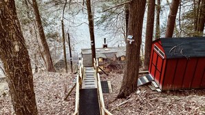 A wooden staircase leading to a cabin in a forested area. - Great Fall pricing! Magical Views & Peaceful Vibes; private dock, kayaks, firepit, office! (Newtown)