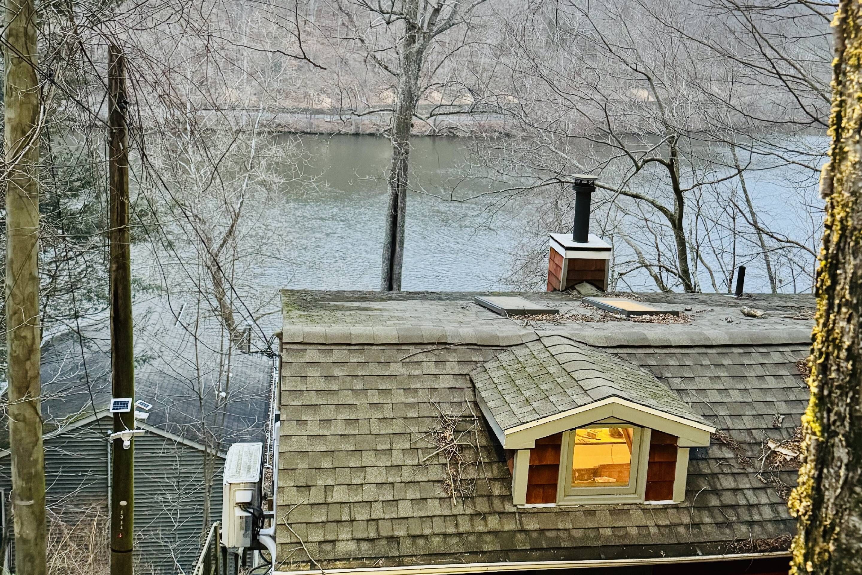 Ein Haus mit einem geneigten Dach, einem Schornstein und einem kleinen Dachfenster.