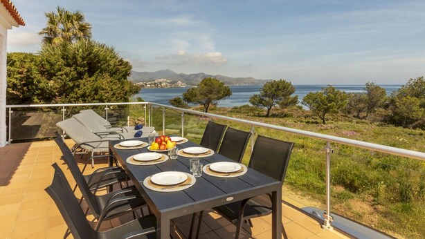An outdoor dining area with a table set for four, overlooking a scenic view of the sea and mountains. - Mon Coeur by Interhome (El Port de la Selva)