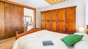 A bedroom with a large bed, wooden wardrobe, and a view of the outside. - Isola Bella: Lake Maggiore View Terrace in Stresa (Stresa)