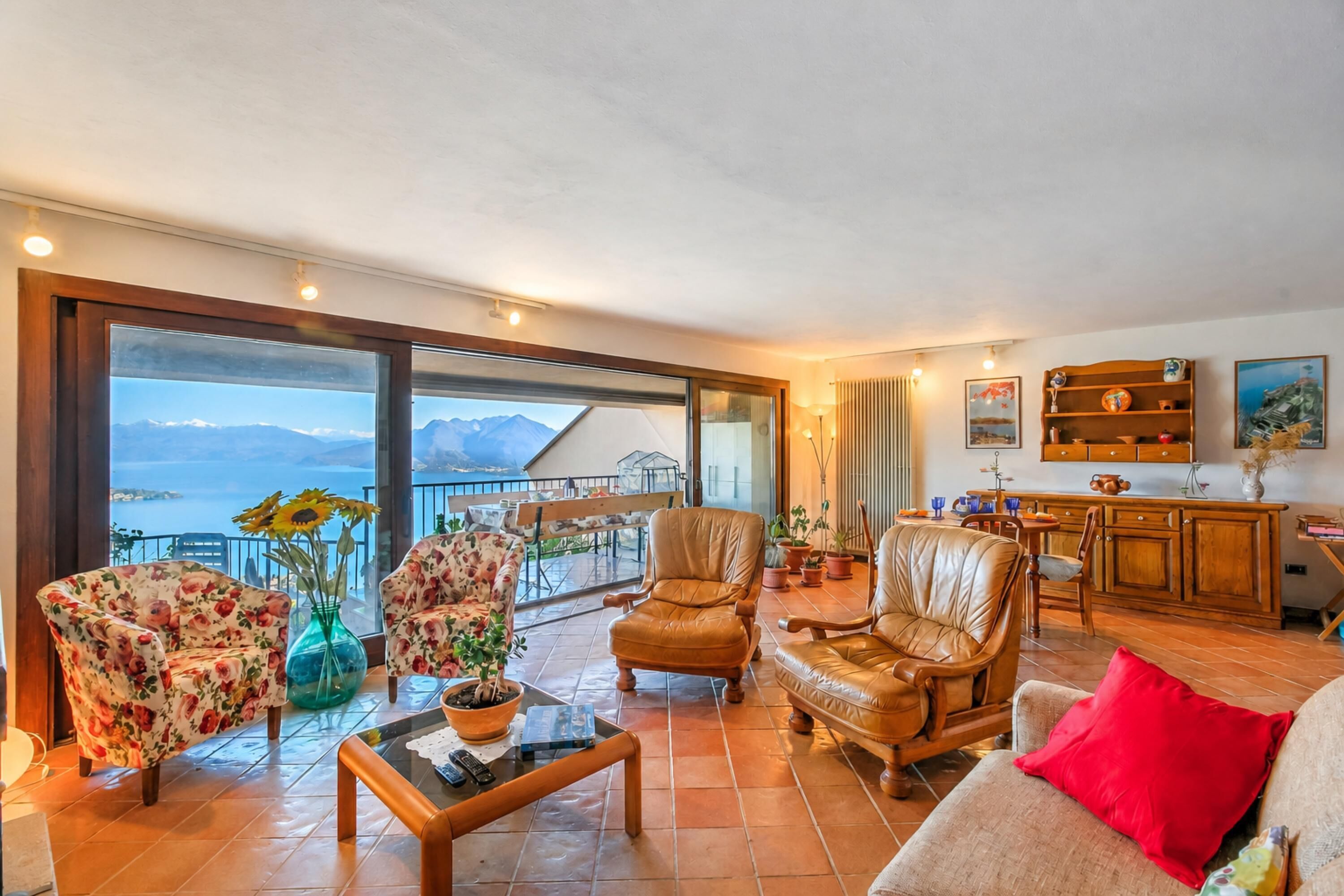 A spacious living area with a balcony overlooking a mountainous landscape.