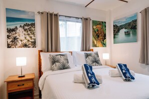 Relax in comfort with a large bed, nightstand, and wall-mounted shelf, surrounded by framed artwork.