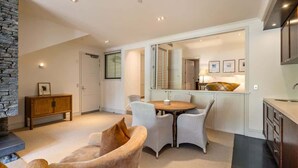 A modern interior with a dining area, kitchen, and a stone accent wall.