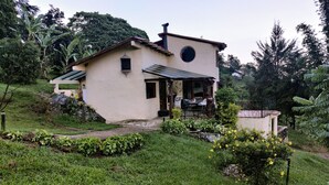 A two-story house with a small porch and a garden.