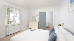 A bedroom with a bed, dresser, and a mirror. - Salubrious Cottage -  a cottage that sleeps 6 guests  in 3 bedrooms (St Ives)