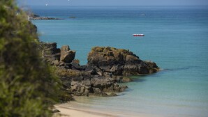 A coastal scene with rocky outcrops, clear blue water, and a sandy beach. - Salubrious Cottage -  a cottage that sleeps 6 guests  in 3 bedrooms (St Ives)
