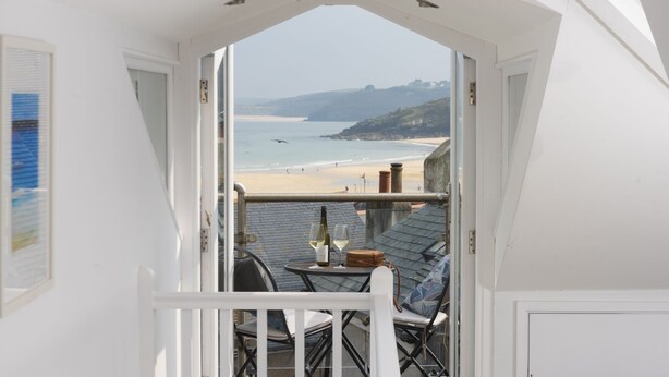 A balcony with a view of a beach and cliffs. - Salubrious Cottage -  a cottage that sleeps 6 guests  in 3 bedrooms (St Ives)
