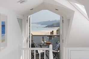 A balcony with a view of a beach and cliffs. - Salubrious Cottage -  a cottage that sleeps 6 guests  in 3 bedrooms (St Ives)
