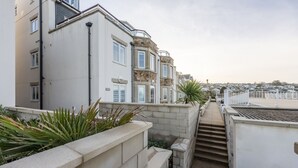 A residential building with a narrow pathway leading to a staircase.